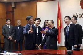Bộ trưởng Bộ Công thương Trần Tuấn Anh đón đồng chí Lộc Tâm Xã. (Ảnh: Trần Việt/TTXVN)