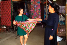 Khách hàng mua sản phẩm dệt thổ cẩm truyền thống. (Ảnh: Chu Hiệu/TTXVN)
