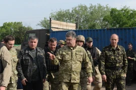 Tổng thống Ukraine Petro Poroshenko (giữa) thị sát một đơn vị chống khủng bố của quân đội ở gần thành phố Izyum thuộc tỉnh miền đông Donetsk ngày 20/6. (Nguồn: AFP/TTXVN)