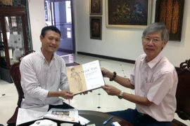 Phóng viên Vietnam+ được ông Tira tặng cuốn sách Tô Ngọc Vân - tấm gương phản chiếu xã hội Việt Nam 1906-1954. (Ảnh: Hà Linh/Vietnam+)