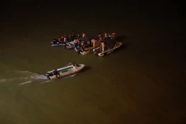 Lực lượng chức năng đang tiến hành tìm kiếm người chiếc ô tô bị nạn. (Ảnh: Hoàng Hùng/TTXVN) 