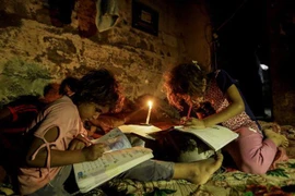 Trẻ em Palestine học bài trong cảnh thiếu điện tại thành phố Gaza. (Nguồn: AFP/TTXVN) 