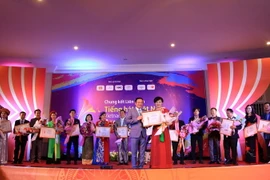 Đại sứ Việt Nam tại Lào Nguyễn Bá Hùng trao giải nhất tại cuộc thi cho thí sinh Nguyễn Thị Kim Liên tại đêm chung kết. (Ảnh: Phạm Kiên/TTXVN)