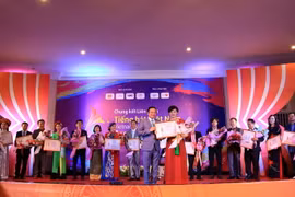 Đại sứ Việt Nam tại Lào Nguyễn Bá Hùng trao giải nhất tại cuộc thi cho thí sinh Nguyễn Thị Kim Liên tại đêm chung kết. (Ảnh: Phạm Kiên/TTXVN)