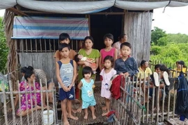 Bà mẹ và 7 đứa trẻ mắn thoát nạn. (Nguồn: TTXVN) 