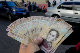 Kiểm tiền mệnh giá 100 Bolivar tại ngân hàng ở Caracas ngày 13/12. (Nguồn: EPA/TTXVN)