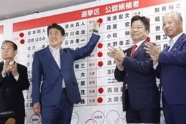 Thủ tướng Nhật Bản, Shinzo Abe gắn những bông hồng nhỏ bên cạnh tên của các ứng cử viên thắng cử của Đảng LDP sau cuộc bầu cử Thượng viện ở Tokyo ngày 21/7. (Nguồn: Kyodo/TTXVN) 