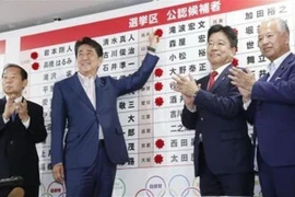 Thủ tướng Nhật Bản, Shinzo Abe gắn những bông hồng nhỏ bên cạnh tên của các ứng cử viên thắng cử của Đảng LDP sau cuộc bầu cử Thượng viện ở Tokyo ngày 21/7. (Nguồn: Kyodo/TTXVN) 