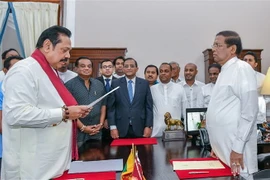 Tổng thống Sri Lanka Maithripala Sirisena (phải) chứng kiến lễ tuyên thệ nhậm chức Thủ tướng mới của ông Mahinda Rajapakse (trái) tại Colombo ngày 26/10. (Nguồn: AFP/TTXVN) 