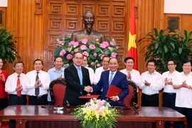 Thủ tướng Chính phủ Nguyễn Xuân Phúc và Chủ tịch Ủy ban Trung ương Mặt trận Tổ quốc Việt Nam Nguyễn Thiện Nhân ký Nghị quyết liên tịch. (Ảnh: Thống Nhất/TTXVN)