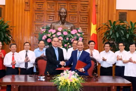 Thủ tướng Chính phủ Nguyễn Xuân Phúc và Chủ tịch Ủy ban Trung ương Mặt trận Tổ quốc Việt Nam Nguyễn Thiện Nhân ký Nghị quyết liên tịch. (Ảnh: Thống Nhất/TTXVN)
