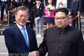 Tổng thống Hàn Quốc Moon Jae-in (trái) bắt tay hữu nghị Nhà lãnh đạo Triều Tiên Kim Jong-un (phải) tại làng đình chiến Panmunjom. (Nguồn: YONHAP/TTXVN) 