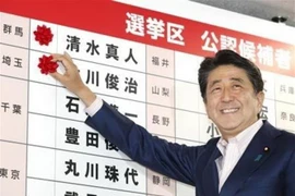Thủ tướng Nhật Bản, Shinzo Abe gắn những bông hồng nhỏ bên cạnh tên của các ứng cử viên thắng cử của Đảng LDP sau cuộc bầu cử Thượng viện ở Tokyo ngày 21/7. (Nguồn: Kyodo/TTXVN) 