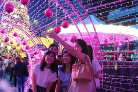 Du khách chụp ảnh tại một trung tâm mua sắm ở thủ đô Bangkok. (Nguồn: THX/TTXVN)