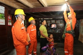Công nhân Công ty Điện lực Lai Châu lắp đặt thiết bị điện cho bà con dân tộc Thái ở huyện Nậm Nhùn. (Ảnh: Ngọc Hà/TTXVN)