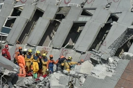 Nhân viên cứu hộ đưa người bị thương ra khỏi hiện trường. (Nguồn: THX/TTXVN)