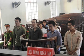 Các bị cáo đứng trước vành móng ngựa chờ nghe tuyên án. (Ảnh: Thanh Tân/TTXVN)