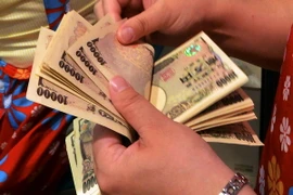 Kiểm đồng yen tại một ngân hàng ở Tokyo tháng 5/2014. (Nguồn: AFP/TTXVN)