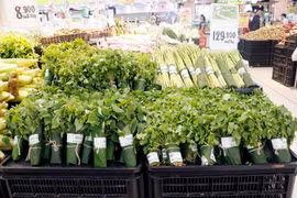 Nhiều kênh phân phối hiện đại đã từng bước sử dụng lá chuối tươi gói thực phẩm, nông sản. (Ảnh: Mỹ Phương/TTXVN) 