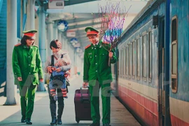 Lực lượng công an giúp đỡ người dân tại ga Hà Nội trong những ngày cuối năm. (Ảnh: PV/Vietnam+)