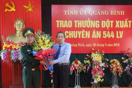Bí thư Tỉnh ủy Quảng Bình Hoàng Đăng Quang tặng hoa cho Đại diện Bộ chỉ huy Bộ đội biên phòng Quảng Bình sau chuyên án 544LV thành công. (Ảnh: Đức Thọ/TTXVN) 