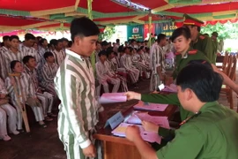 Giám thị Trại giam Gia Trung (Bộ Công an) trên địa bàn tỉnh Gia Lai làm thủ tục trao Quyết định đặc xá của Chủ tịch nước cho phạm nhân được đặc xá năm 2015. (Ảnh: Hoài Nam/TTXVN)