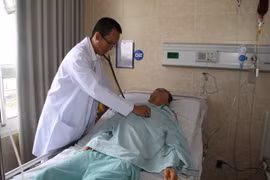 Bác sỹ Quản Minh Trị, Phó khoa ngoại lồng ngực, Bệnh viện Đa khoa Đồng Nai thăm khám cho bệnh nhân Nguyễn Ngọc Tài sau khi phẫu thuật cắt bỏ khối phổi biệt lập và thùy dưới phổi trái. (Ảnh: Lê Xuân/TTXVN)