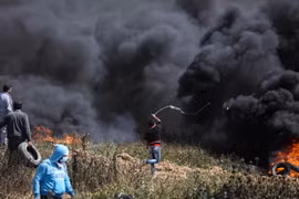 Người biểu tình Palestine đốt lốp xe và ném đá vào binh sỹ Israel trong cuộc biểu tình dọc biên giới giữa khu vực phía Đông Dải Gaza và Israel. (Nguồn: THX/TTXVN) 