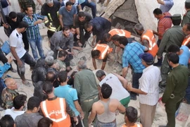 Tìm kiếm người sống sót sau một vụ pháo kích ở Syria. (Nguồn: AFP/TTXVN)