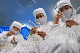 Công nhân làm việc tại một nhà máy sản xuất thiết bị y tế ở tỉnh Giang Tô, Trung Quốc. (Nguồn: AFP/TTXVN) 