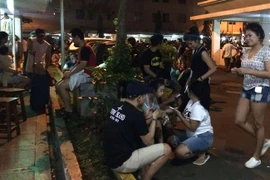 Người dân Indonesia tụ tập dưới tòa nhà sau một trận động đất. (Nguồn: AFP)