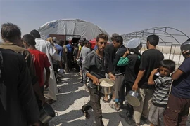 Người tị nạn Syria xếp hàng nhận thức ăn cứu trợ tại một trại tạm ở Ras al-Ain, giáp giới với Thổ Nhĩ Kỳ. (Nguồn: AFP/TTXVN) 