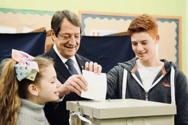 Tổng thống Cyprus Nicos Anastasiades (giữa) bỏ phiếu tại một điểm bầu cử ở Limassol ngày 28/1. (Nguồn: THX/TTXVN)