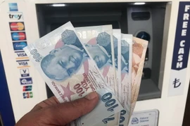 Kiểm đồng lira tại một máy rút tiền tự động ở Istanbul, ngày 14/8. (Nguồn: THX/TTXVN)