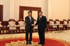 Thủ tướng Chính phủ Thongloun Sisoulith đón Phó Thủ tướng Phạm Bình Minh. (Ảnh: Phạm Kiên/TTXVN)