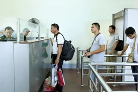 Hành khách chờ làm thủ tục nhập cảnh tại cửa khẩu Móng Cái. (Ảnh: Hoàng Hùng/TTXVN)