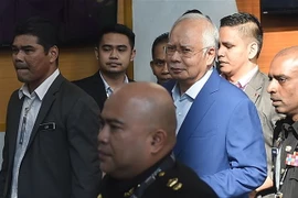 Cảnh sát áp giải cựu Thủ tướng Malaysia Najib Razak (giữa) tới Văn phòng Ủy ban chống tham nhũng ở Putrajaya ngày 22/5. (Nguồn: THX/TTXVN)