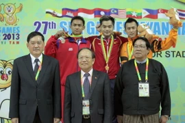 Bộ trưởng Hoàng Tuấn Anh (giữa, hàng trước) trao huy chương cho vận động viên Phạm Quốc Khánh (giữa, hàng sau). (Ảnh: Quang Nhựt/TTXVN)