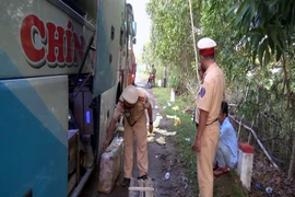 Lực lượng Cảnh sát giao thông kiểm tra xe khách mang biển số 76B -00317 thuộc Công ty Xe khách Chín Nghĩa. (Ảnh: Đoàn Hữu Trung/TTXVN)