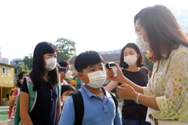 Kiểm tra thân nhiệt của các học sinh tiểu học ở thủ đô Seoul nhằm ngăn chặn lây nhiễm MERS. (Nguồn: THX/TTXVN)