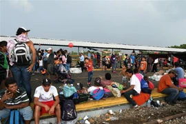 Người di cư trong hành trình đến Mỹ chờ đợi để đi qua khu vực biên giới từ Ciudad Tecun Uman, Guatemala, tới Ciudad Hidalgo, Mexico, ngày 21/10/2018. (Nguồn: AFP/TTXVN) 