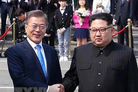 Tổng thống Hàn Quốc Moon Jae-in (trái) bắt tay hữu nghị Nhà lãnh đạo Triều Tiên Kim Jong-un (phải) tại làng đình chiến Panmunjom. (Nguồn: YONHAP/TTXVN)