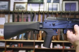 Thiết bị 'bump stock' (trái) được gắn vào khẩu súng bán tự động AK-47 (phải) tại một cửa hàng ở bang Utah, Mỹ ngày 1/10. (Nguồn: AFP/TTXVN)
