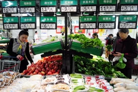 Khách hàng chọn mua rau quả tại một siêu thị ở tỉnh Giang Tô. (Nguồn: AFP/TTXVN)