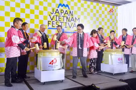Các thành viên Ban tổ chức thực hiện nghi thức đập rượu Sake truyền thống Nhật Bản. (Ảnh: Gia Thuận/TTXVN)