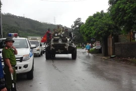 Xe thiết giáp đưa dân khỏi vùng ngập lụt tại Uông Bí, Quảng Binh. (Ảnh: Nguyễn Hoàng/TTXVN)