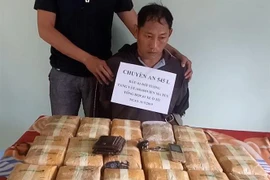Đối tượng người Lào Thạo Phết, sinh năm 1969, cùng tang vật tại cơ quan công an. (Nguồn: TTXVN) 