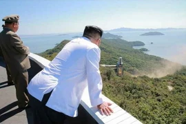 Nhà lãnh đạo Triều Tiên Kim Jong-un (phải) thị sát việc thử nghiệm trên mặt đất động cơ tên lửa công suất lớn tại Trung tâm vũ trụ Sohae, Triều Tiên. (Nguồn: Yonhap/TTXVN)