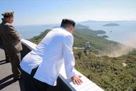 Nhà lãnh đạo Triều Tiên Kim Jong-un (phải) thị sát việc thử nghiệm trên mặt đất động cơ tên lửa công suất lớn tại Trung tâm vũ trụ Sohae, Triều Tiên. (Nguồn: Yonhap/TTXVN)
