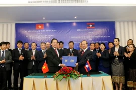 Hai Bộ trưởng đang trao nhau Thỏa thuận hợp tác về Kế hoạch hành động chung giữa hai bên. (Ảnh: Phạm Kiên/Vietnam+)